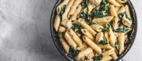 Pasta,In,Pan,With,Spinach,And,Chicken,On,Grey,Background